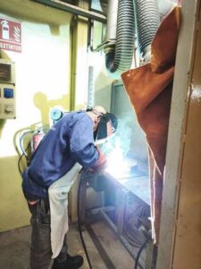 Alumno soldando con electrodo revestido en una cabina del taller de ITMETAL
